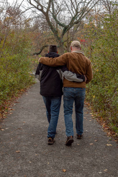 istock Middle aged gay couple walking their dog. 1283978769
