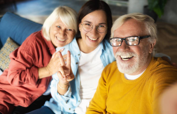 istock Happy seniors with granddaughter take selfie sofa 1283980636