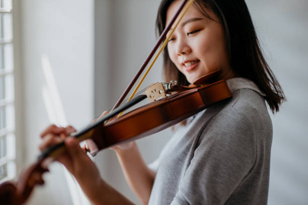 istock An Asian Chinese woman practicing violin at home 1283984187