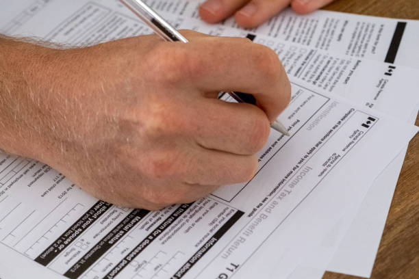 istock Young male completing his Canadian TAX return 1283987487