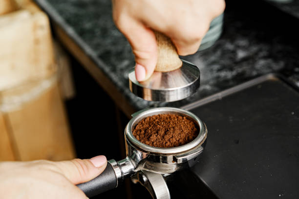 istock Woman coffee shop worker preparing coffee on professional coffee machine 1283990679
