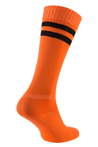 orange soccer leggings or socks with a black stripe, as if walking, on a white background orange soccer leggings or socks with a black stripe, as if walking, on a white background, isolate football socks stock pictures, royalty-free photos & images