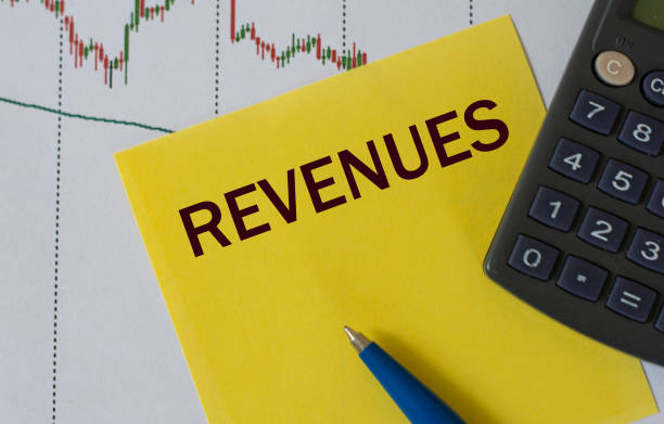 istock REVENUES word on yellow sheet on table with pen, calculator and graph 1283993666