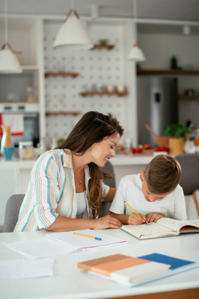 istock Mother helping her son with homework at home. 1283995046