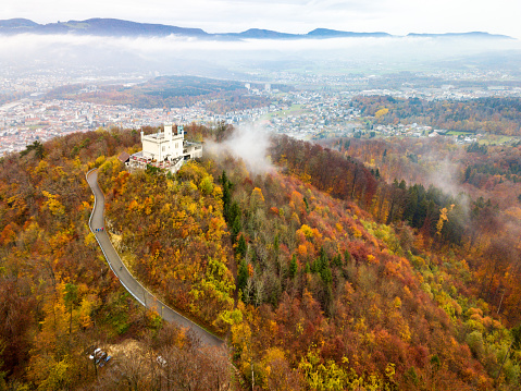 Oftringen, Switzerland - 01 November 2020: the Saelischloessli castle among the colorful autumn forest trees by drone aerial photography