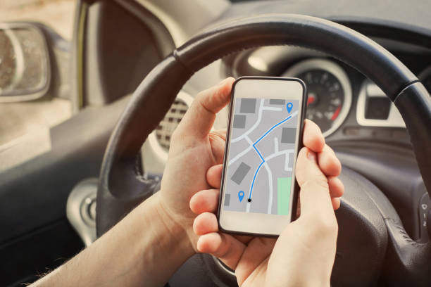 driver using direction navigation on GPS map on the screen of mobile phone driver using direction navigation on GPS map on the screen of mobile smartphone in the car tracker stock pictures, royalty-free photos & images