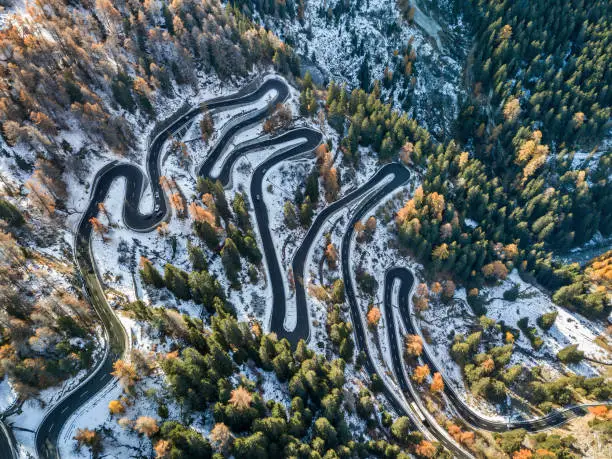 Aerial view by drone on the most spectacular pass road in Swiss Alps - Maloja Pass in early winter and autumn season, Grison, Switzerland