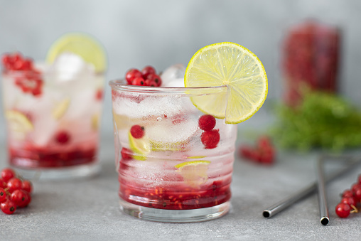 summer cocktail with red currants, lime and syrup in glass