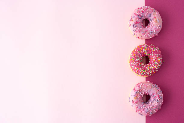 istock three donuts with glaze on a pink background, top view 1284000136