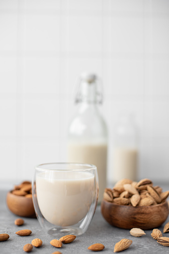 homemade almond milk in glasses and bottle ob table