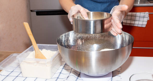 istock Sifting flour with a sieve into a metal bowl. 1284001705