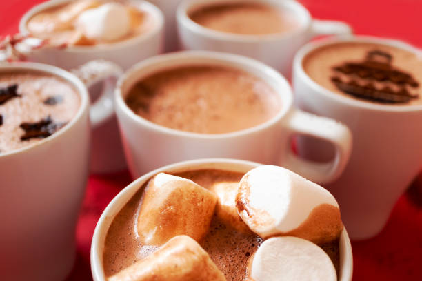 istock Close-up many white mugs with hot cocoa and marshmallows with selective focus. Winter drinks 1284001946