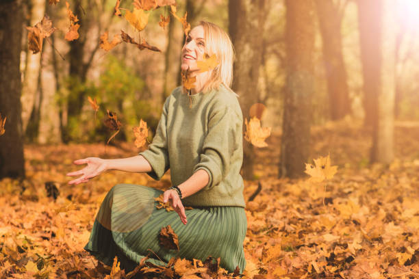 istock Woman catching maple tree leaves in autumn 1284003320