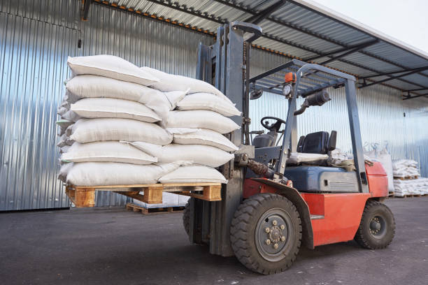 istock Red forklift lifts pallet with heavy bags 1284004810