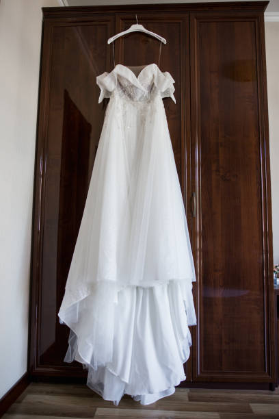 istock bride's wedding dress hanging on the wardrobe 1284004896