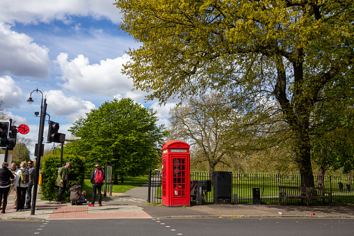 Primrose Hill in Borough of Camden, London. People can be seen gathered outside the entrance gate.
