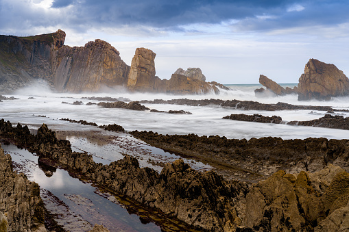 A rocky and wild coast with stormy waves hitting the shore