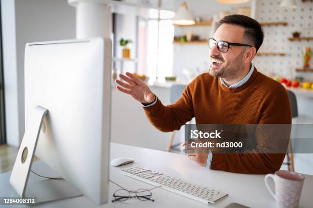 Man Having Video Conferencing Call Via Computer Working Remotely Managing Team And Work From Home Stock Photo - Download Image Now