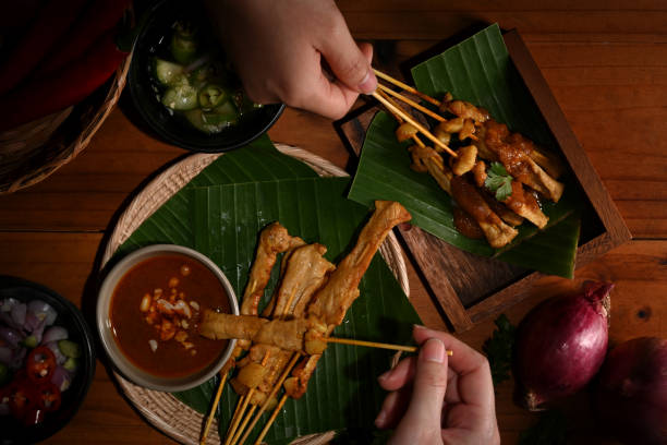 istock Hands holding Grilled pork satay (Moo Satay) ready to eat 1284008392