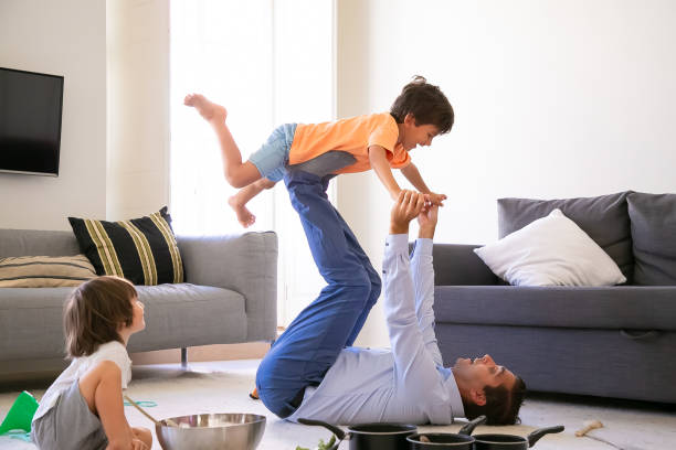 istock Exited father holding son on legs and lying on carpet 1284009955