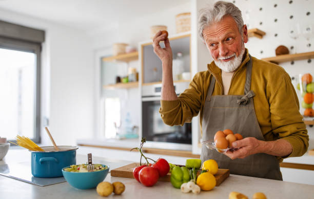 istock Happy retired senior man cooking in kitchen. Retirement, hobby people concept 1284010177