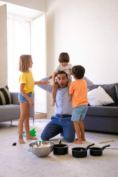 istock Exited father having fun with children in living room 1284011009