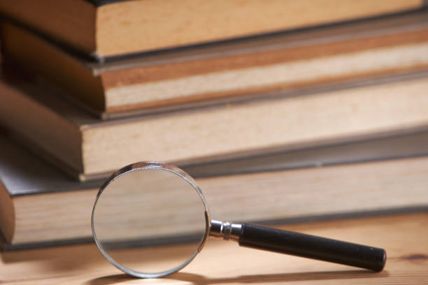 istock Stack of books with magnifying glass . Search information. 1284011225