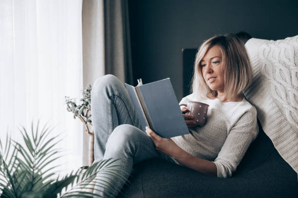 istock woman reading a book at home 1284011234