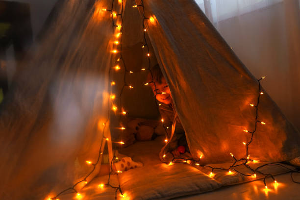 istock Magic tent with garland home, boy inside. 1284011472