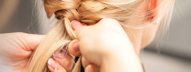 istock Female hands braiding pigtail to woman 1284011900