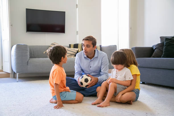 istock Caucasian dad holding ball and talking with children 1284012689