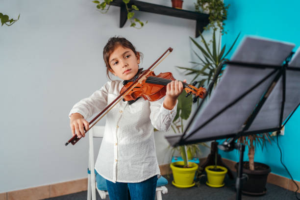 istock Little girl playing violin 1284013220