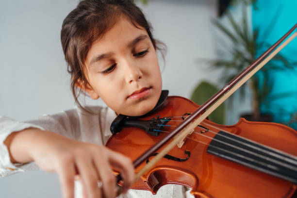 istock Little girl playing violin 1284013240