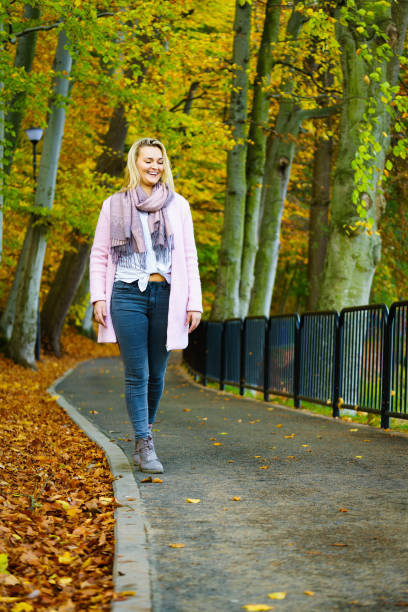 istock Woman walking in autumn park 1284015043