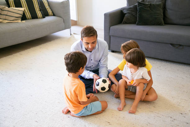 istock Caring dad holding ball and telling children story 1284015189