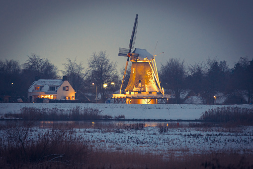 Evening view on the D' Olde Zwarver old windmill in the city of Kampen next to the river IJssel in winter in Holland. Kampen is an ancient Hanseatic League in Overijssel, The Netherlands.