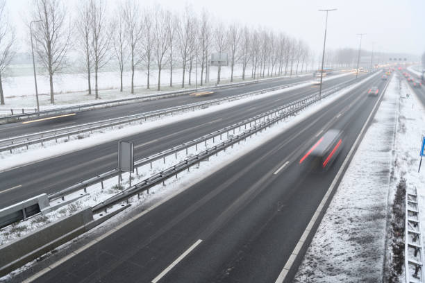 istock Traffic driving on a multiple lane highway during a snow blizzard in winter 1284017594