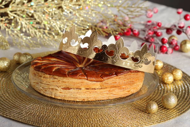 gâteau de rois d’épiphanie avec une couronne de papier d’or et un petit charme de porcelaine à l’intérieur. galette des rois. - galette des rois photos et images de collection