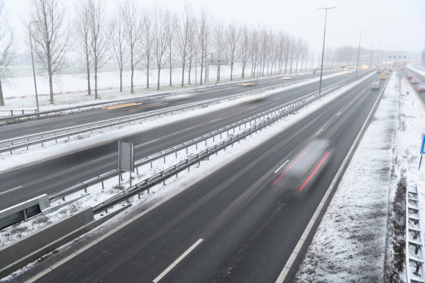 istock Traffic driving on a multiple lane highway during a snow blizzard in winter 1284017694