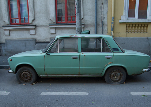 Old passenger car parked in the city, abandoned.