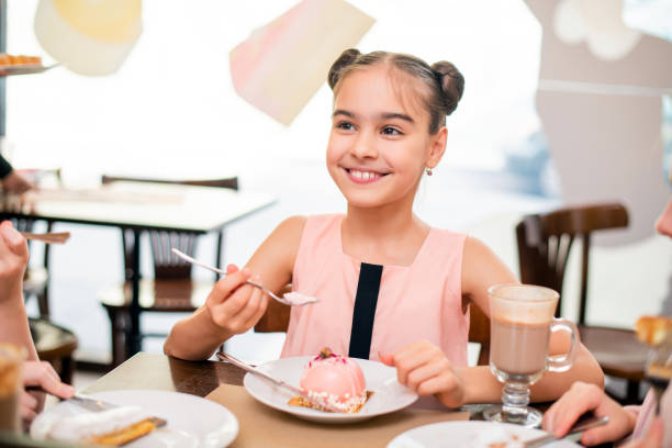 istock Girl eating cake in cafe smiling with beautiful white teeth 1284018872