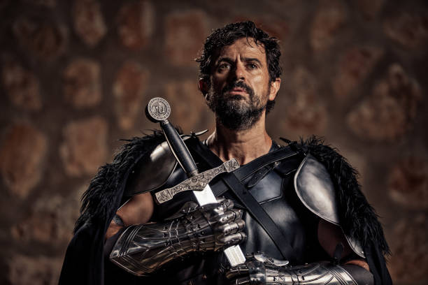 istock Devout mature fantasy medieval knight holding his sword in front of him while he is praying 1284018894