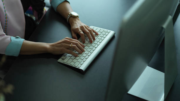 istock Female hands typing on wireless computer keyboard on office desk 1284019431
