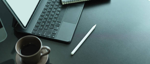 istock Office desk with mock up laptop, keyboard, stylus, coffee cup and copy space 1284019477