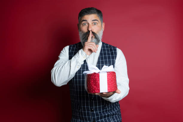 istock ortrait of hipster man with a gift making a surprise gesture over red background 1284020663