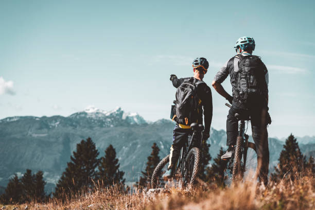 istock Two mountain biker looking at a view of the mountains 1284021016