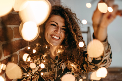 Dream like photo of women holding group of light bulbs and smiling