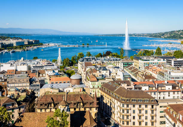 High angle view over the bay of Geneva. High angle view over the rooftops of Geneva, Switzerland, the bay of Geneva with the Jet d'Eau water jet fountain and the Lake Geneva, from the bell tower of the cathedral on a sunny summer day. geneva switzerland photos stock pictures, royalty-free photos & images