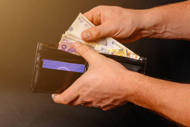 hryvnia ucraniana en un bolso negro, un hombre tiene en sus manos. - ukraine hryvnia currency paper currency fotografías e imágenes de stock