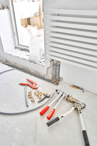 istock Tools for Work As A Plumber. Connection heating pipes to white Radiator in a new apartment under construction. water heating radiator on the white wall indoors 1284025659